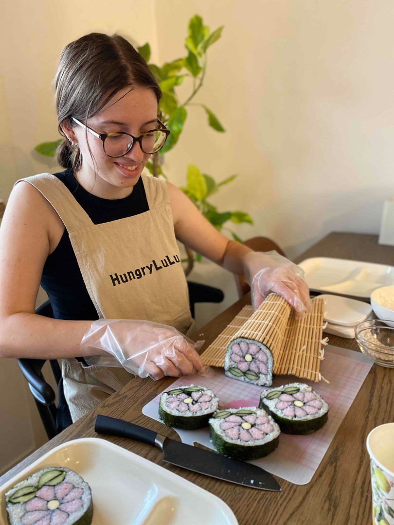 Five language students sit at a table participating on japanese cooking workshop