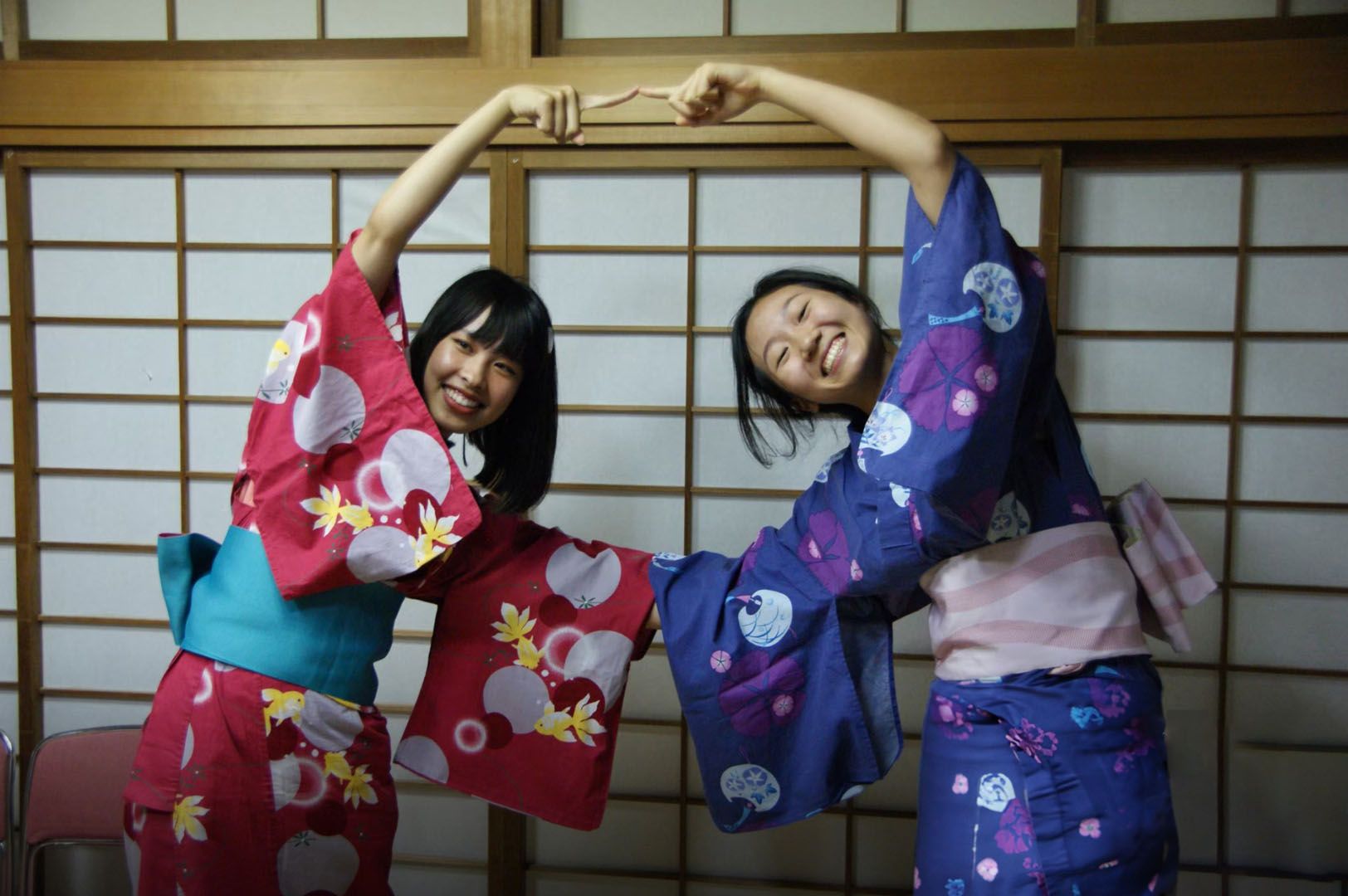 Language students wearing traditional kimonos in a japanese restaurant in front of their meals