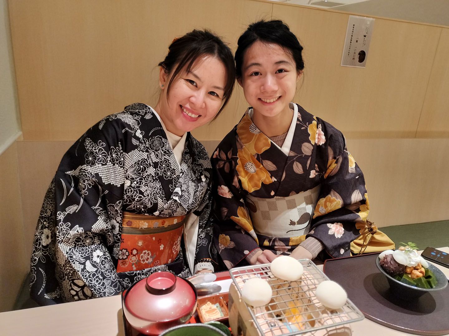 Language students wearing traditional kimonos in a japanese restaurant in front of their meals