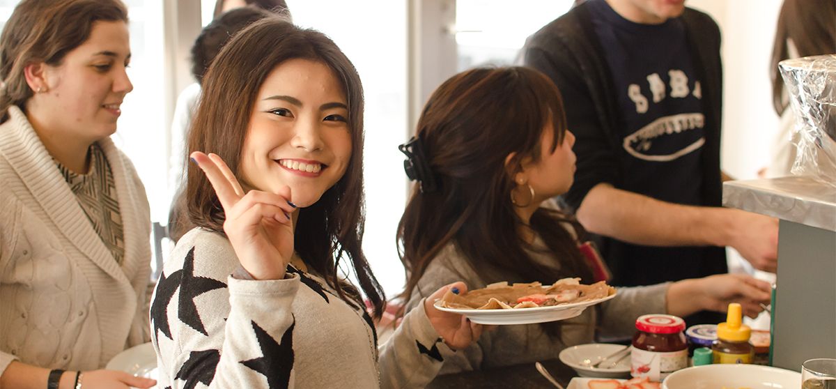 Group of language students eating diverse sweets at a food party