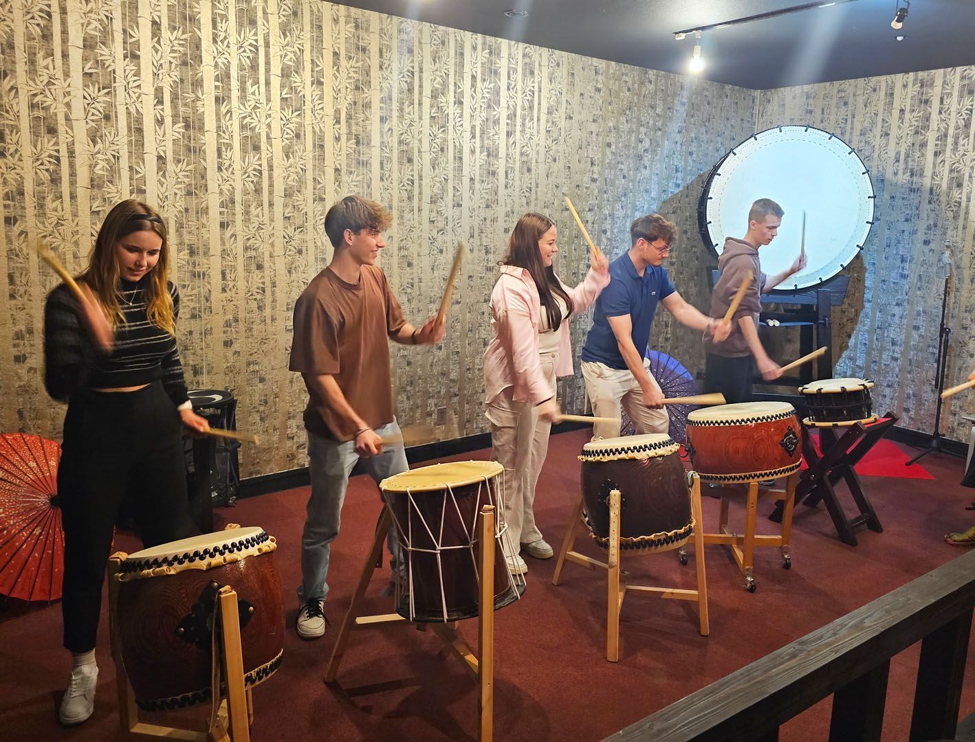 Language students playing on traditional taiko drums