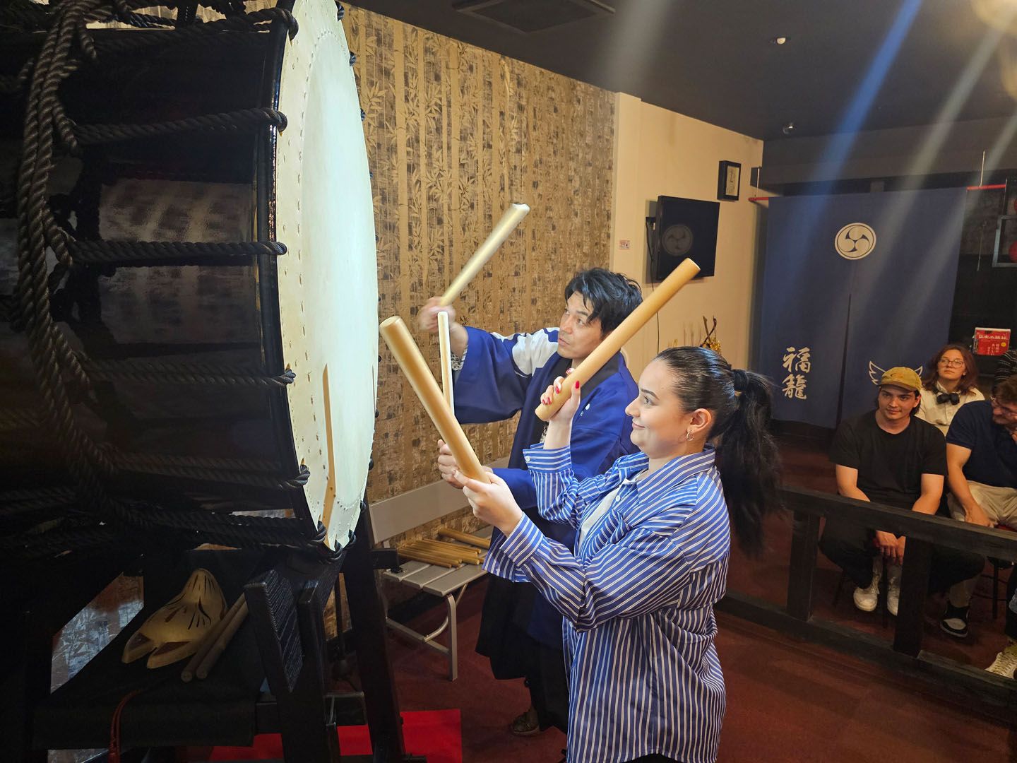 Language students playing on traditional taiko drums