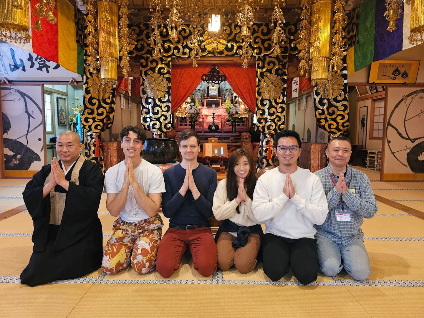 Language students pray in front of japanese temple