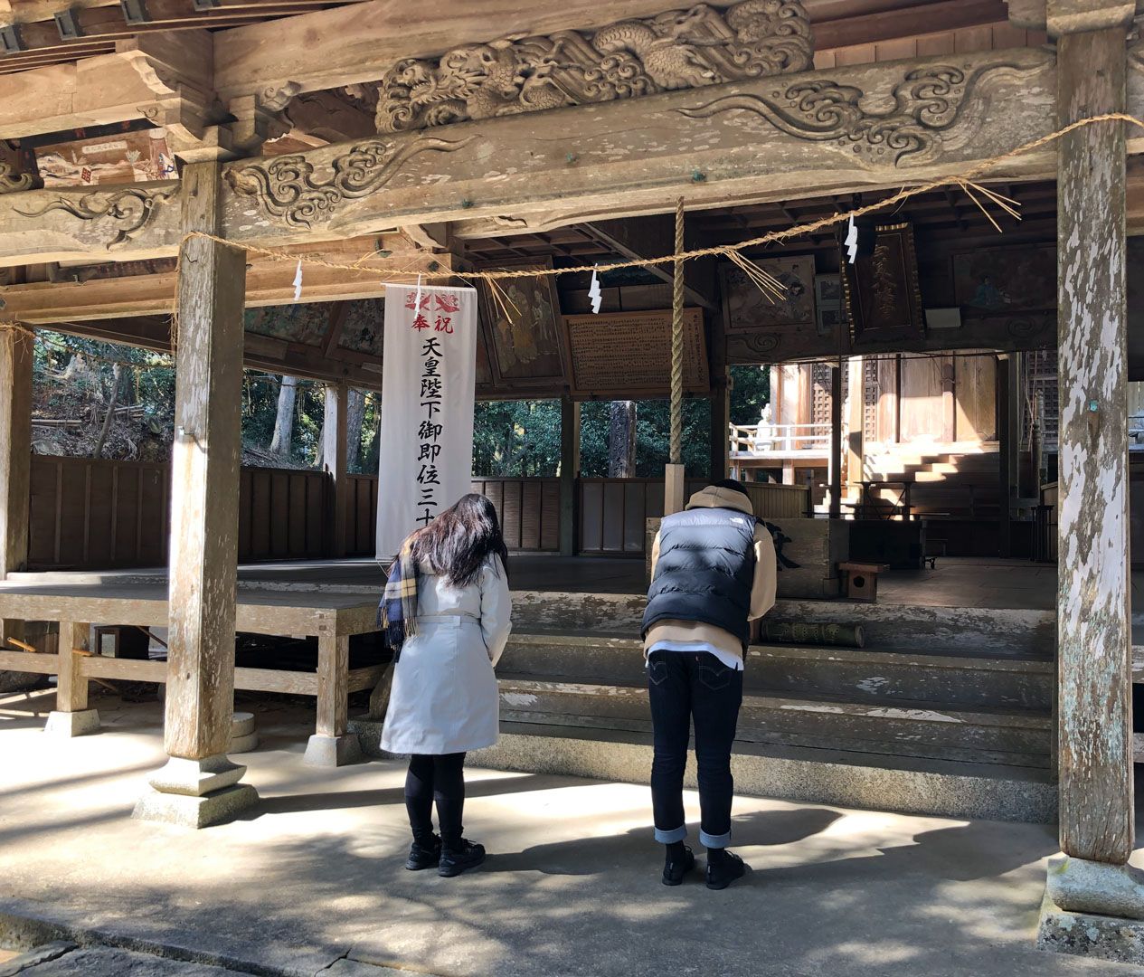 Language students pray in front of japanese temple