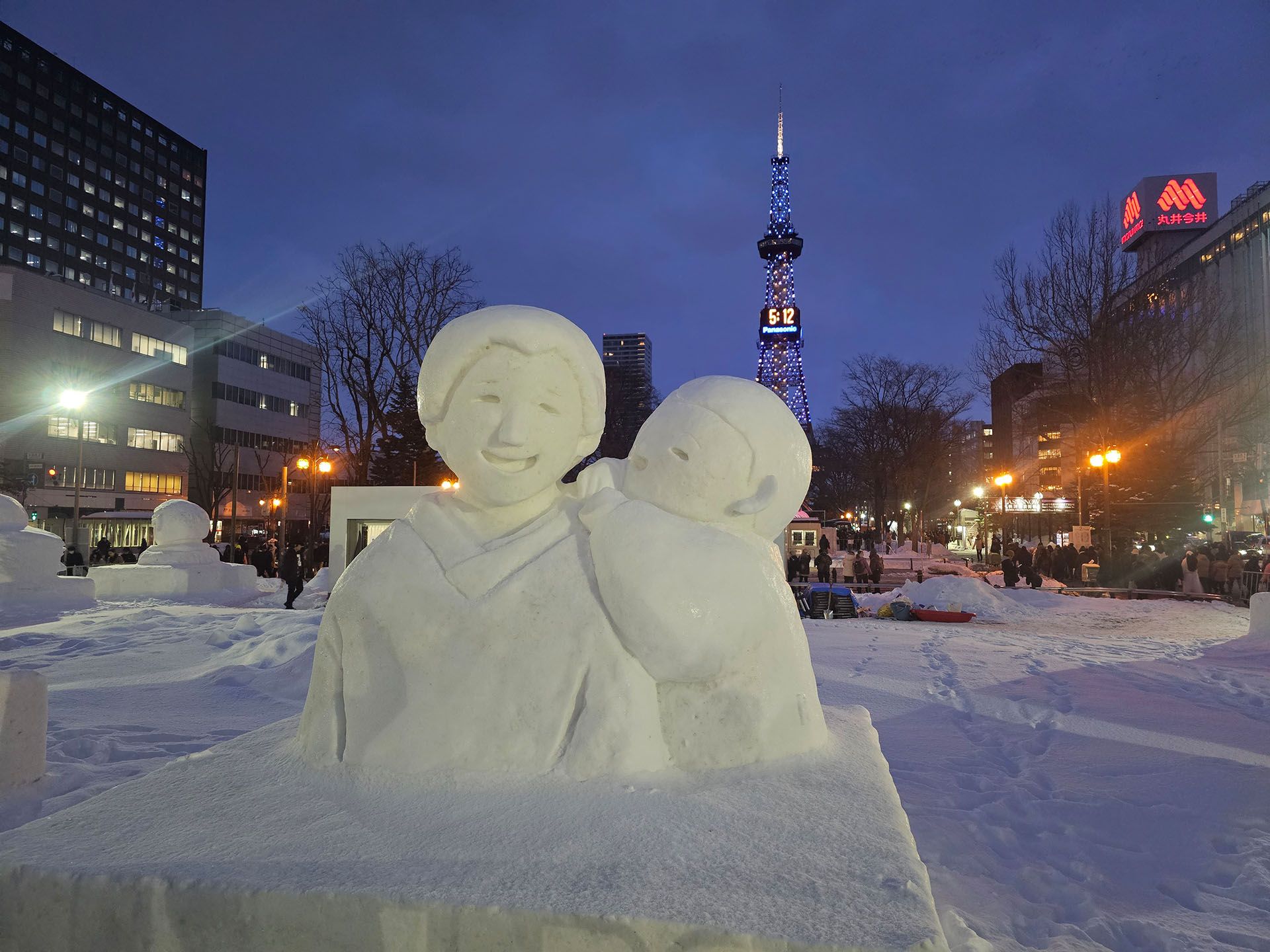 People statue made out of snow outside in the evening