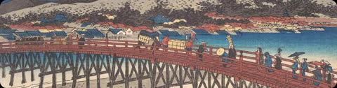 A group of people carrying goods walks across a long red bridge over water, with a village and snowy hills on the far shore.