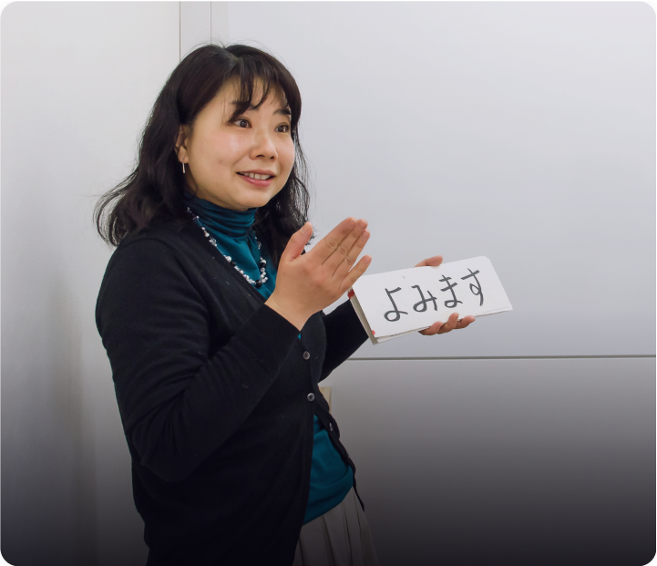 Language teacher showing hiragana learning card