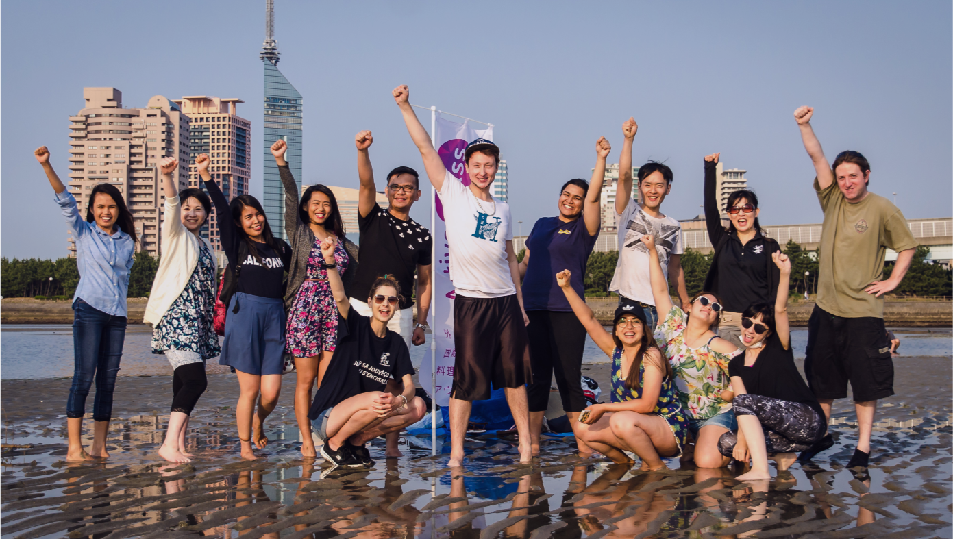 Multiple language students cheer at the beach