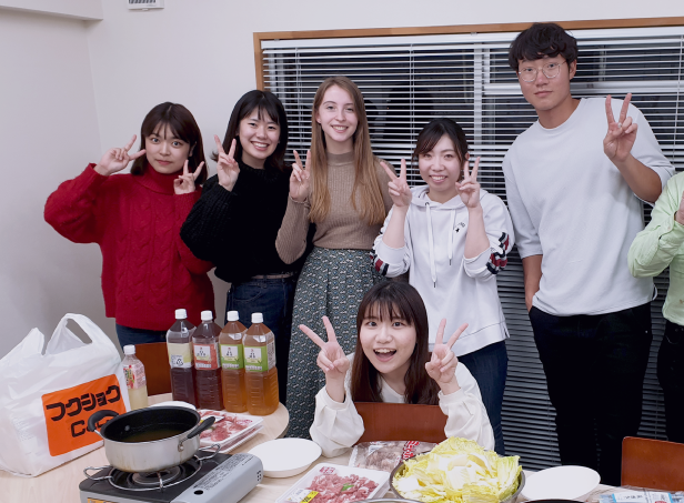 Language students posing while having a japanese food party