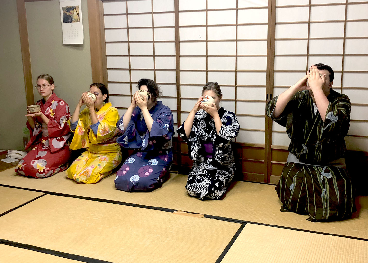 Language students drinking traditional japanese tea, wearing a kimono